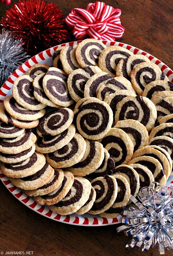 Top down view of a cookie platter filled with Chocolate Pinwheel cookies, fanned out in a spiral pattern.