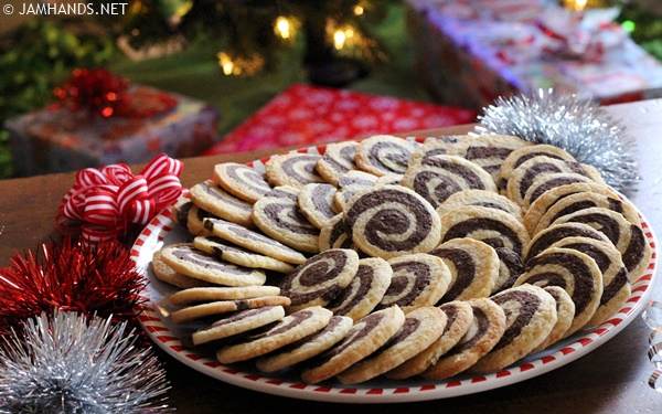 Side view of a cookie platter filled with Chocolate Pinwheel cookies, fanned out in a spiral pattern.