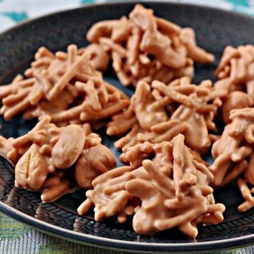 Plate filled with Butterscotch Cashew Haystacks: Melted butterscotch morsels, chow mein noodles and cashews in mounds, hardened.