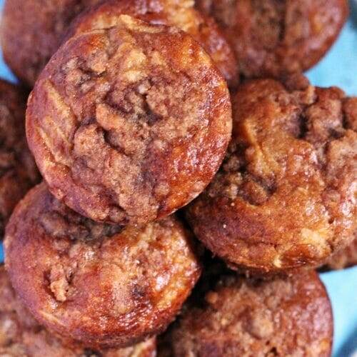 Apple Pie Streusel Muffins stacked in a pyramid on a plate.