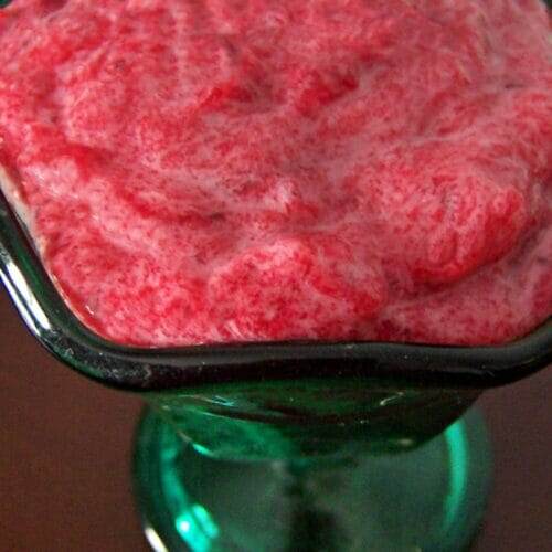 Ruby red cranberry butter in a jade green dessert glass.